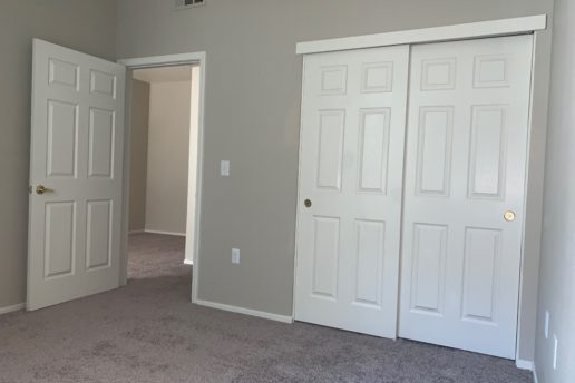 Carpeted bedroom with sliding doors to closet