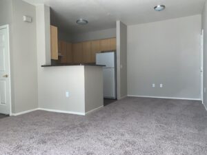 Affordable Apartments for Rent in Elk Grove - Kitchen with White Appliances, Natural Cabinets, and Open to Dining Area.